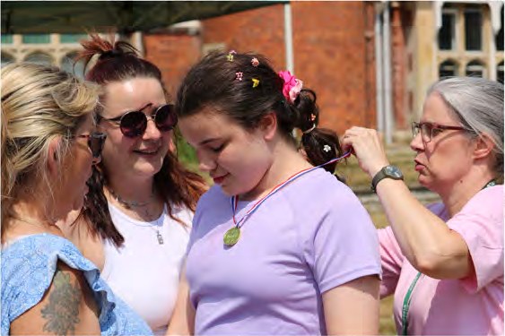 A young person being presented with a Sports Day medal